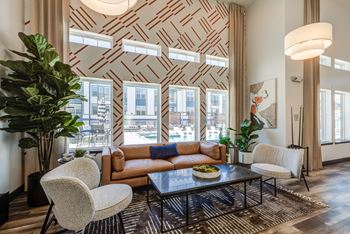 a living room with a couch and chairs and a coffee table